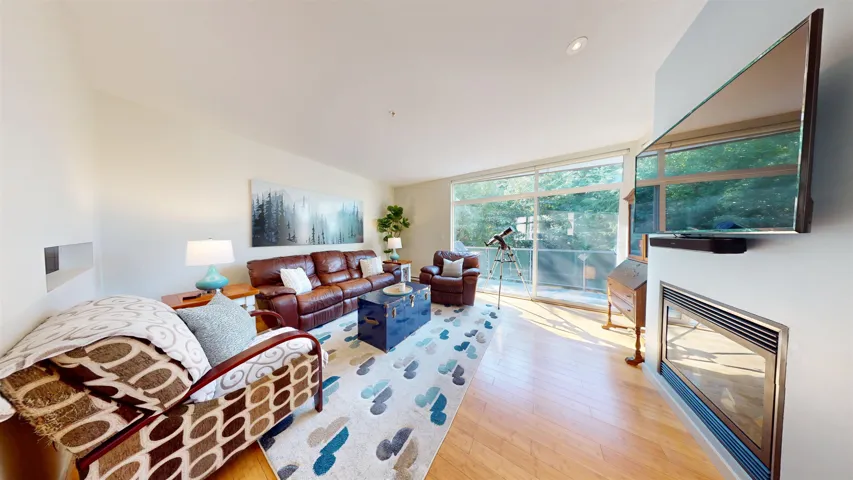 Living room featuring light wood-style flooring and a wall of windows