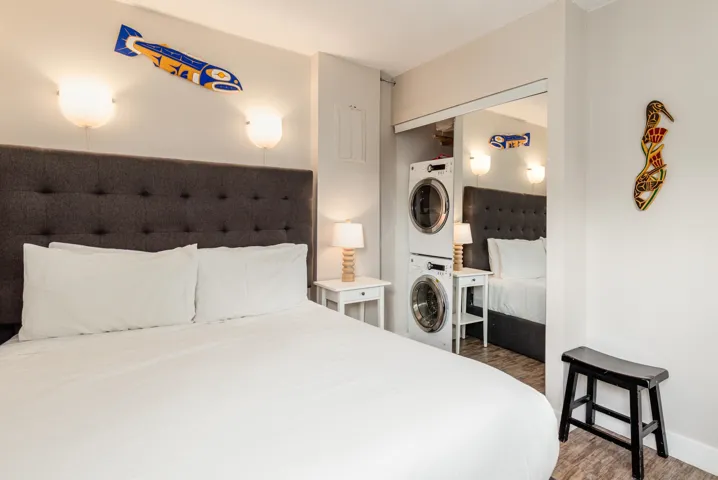 Bedroom with stacked washer and dryer and wood finished floors