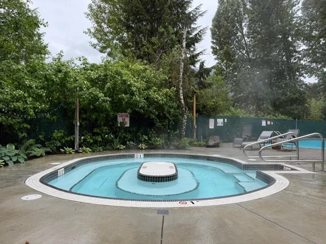 Inviting circular spa with tiled steps and a central tiled feature