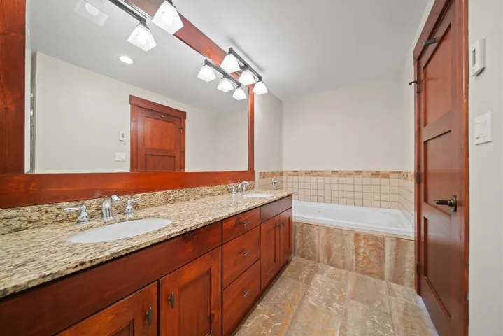 Full bath with double vanity, a garden tub, and recessed lighting