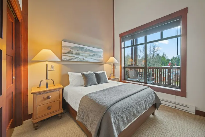 Carpeted bedroom with a baseboard heating unit