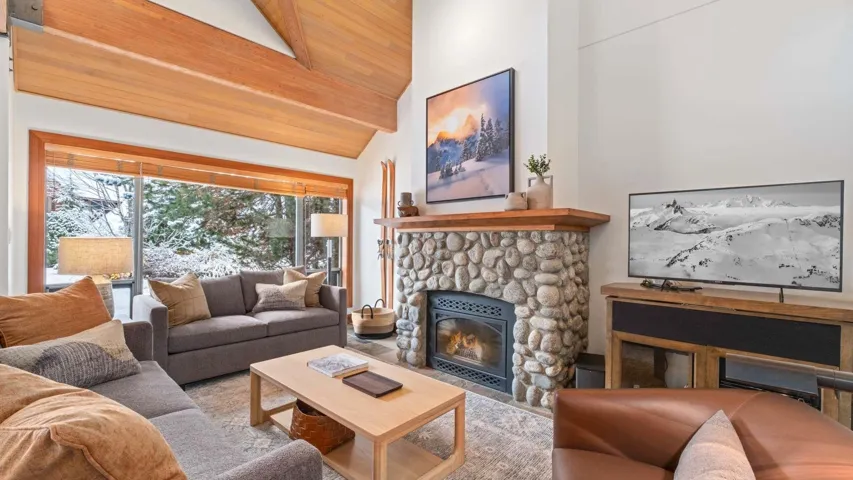 Living room featuring a fireplace, high vaulted ceiling, and a wood ceiling with exposed beams