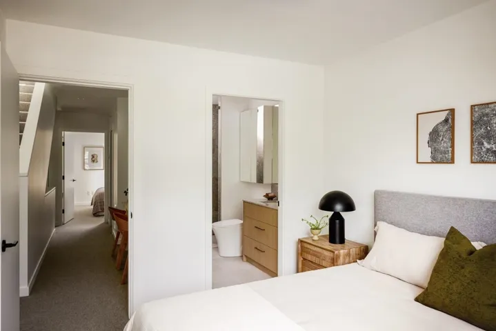 Bedroom featuring a textured fabric headboard and a hardwood nightstand