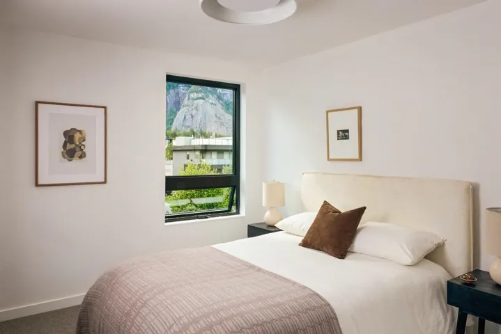 Room featuring a mountain backdrop through a dark-framed window