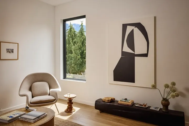 Expansive window framing a mountain and tree-lined landscape