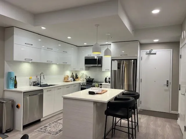 Kitchen featuring white cabinets, modern cabinets, appliances with stainless steel finishes, and a sink