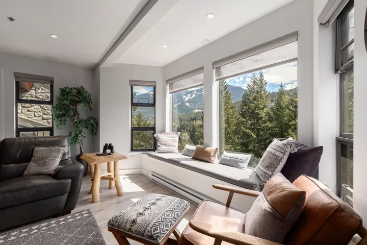 Living area featuring a built-in window seat, large picture windows, wood-finish flooring, recessed lighting, and a mountain landscape