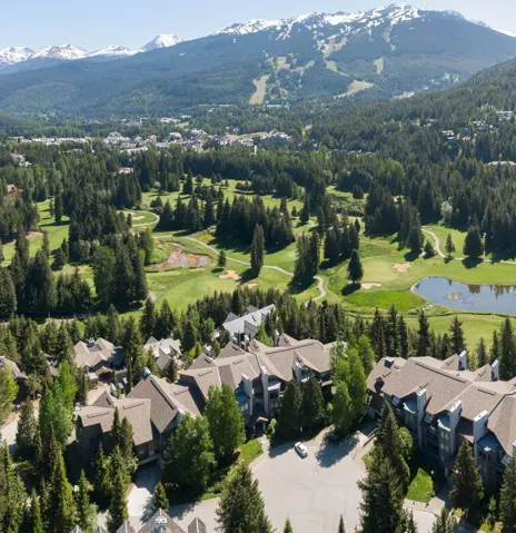 Multi-story buildings featuring gabled roofs, stone facades, and balconies
