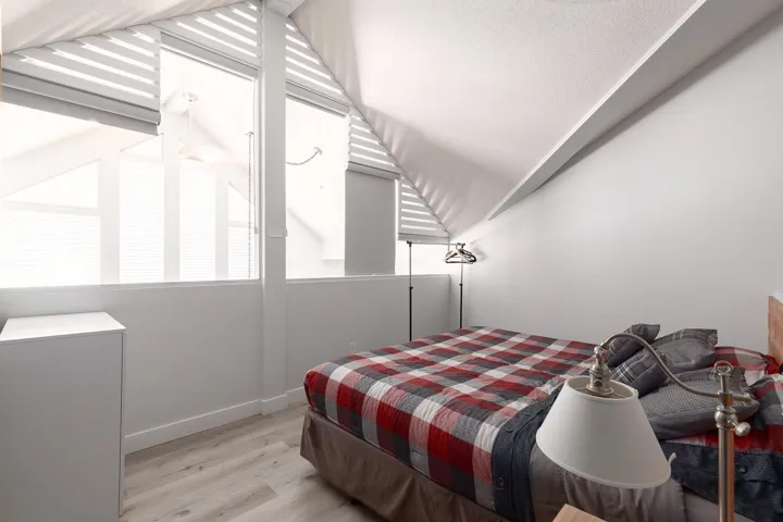 Room with sloped ceilings and light wood-finish flooring