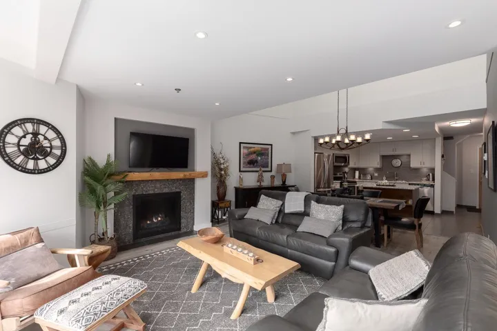 Living area featuring a gas fireplace with a stone surround and a substantial wood mantel
