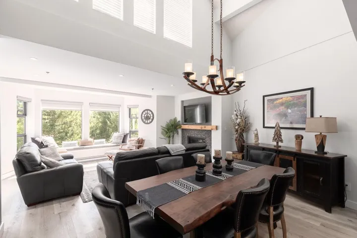 Vaulted ceiling living and dining area with light wood-finish flooring