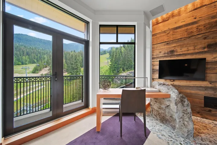 Dining area with wooden walls and a forest view