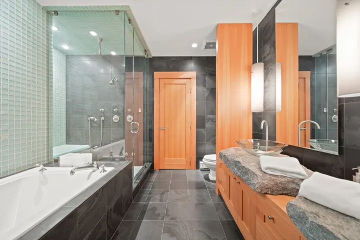 Bathroom featuring tile walls, a shower stall, a garden tub, double vanity, and tile patterned flooring