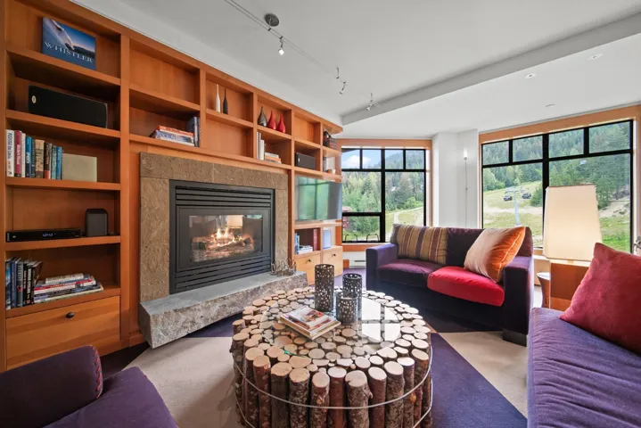 Living room with a premium fireplace, track lighting, and carpet flooring