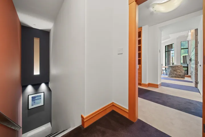 Corridor with carpet flooring and baseboards