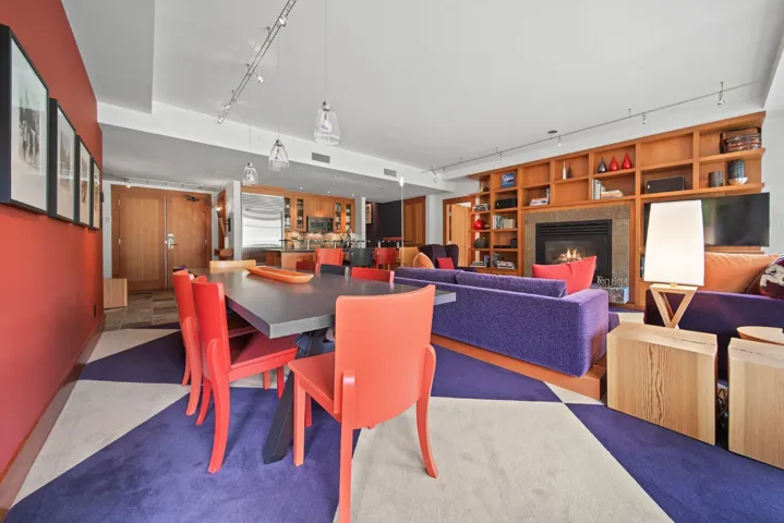 Dining area with track lighting, a high end fireplace, and built in features