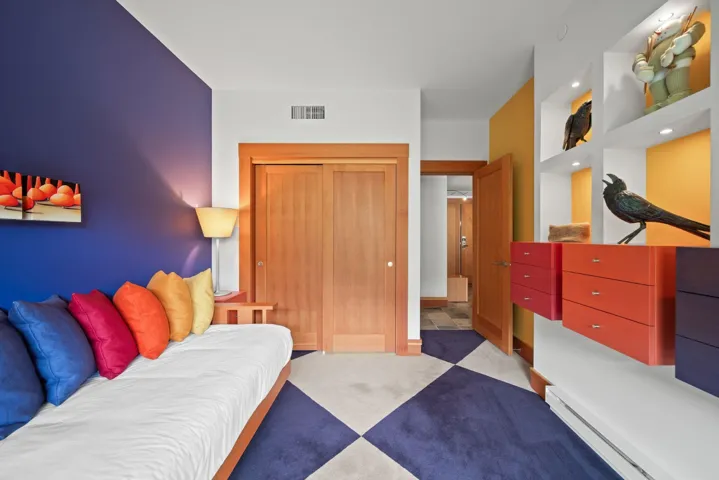 Carpeted bedroom with a baseboard radiator and a closet