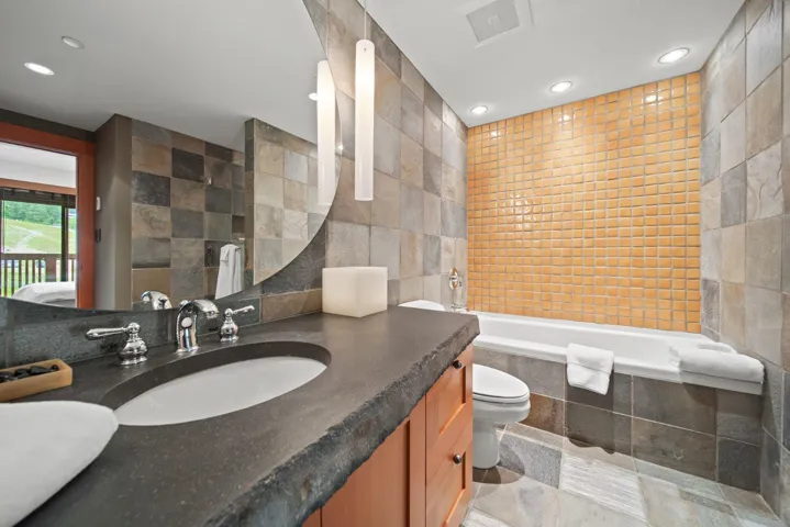 Bathroom with tile walls, a relaxing tiled tub, vanity, recessed lighting, and tiled shower