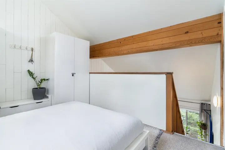 Bedroom with lofted ceiling with beams and carpet