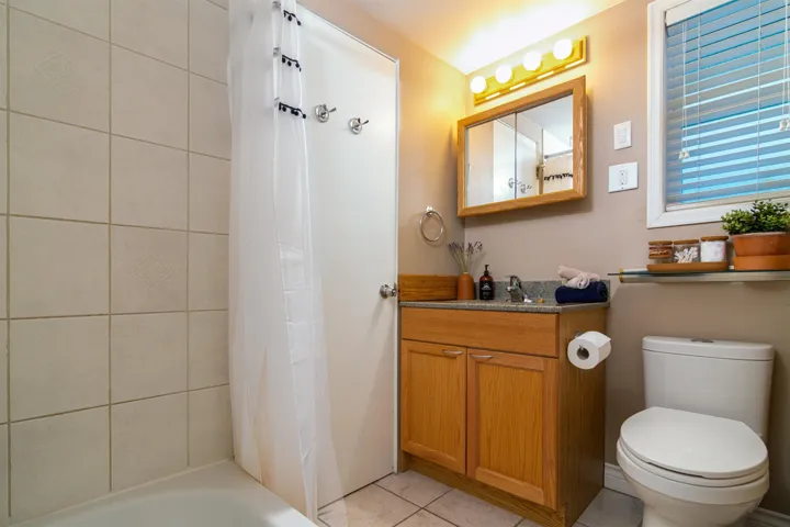 Bathroom with tile patterned flooring, vanity, toilet, and shower / bath combo