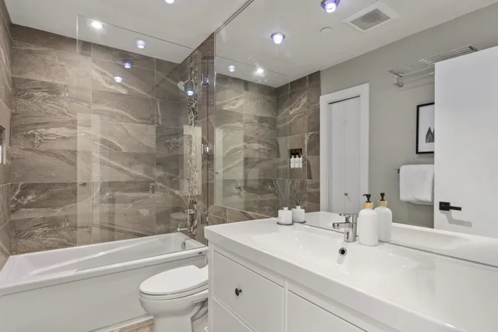 Bathroom featuring bathtub / shower combination, vanity, and recessed lighting
