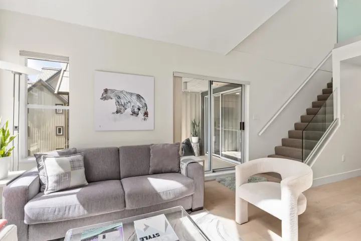 Living area with stairs, plenty of natural light, and wood finished floors