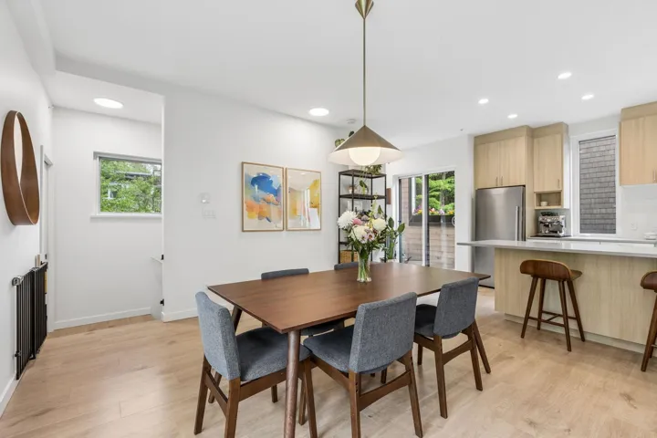 Open-concept dining area featuring light wood-finish flooring, a contemporary pendant light fixture, and recessed lighting