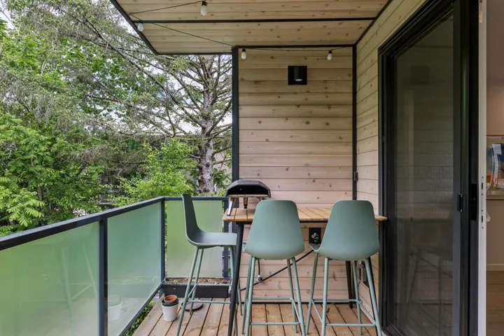Covered outdoor balcony featuring wood plank flooring and wood paneling