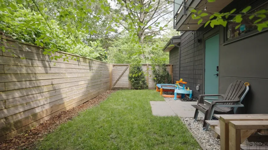 Manicured lawn area with a solid wood privacy fence and a convenient side gate