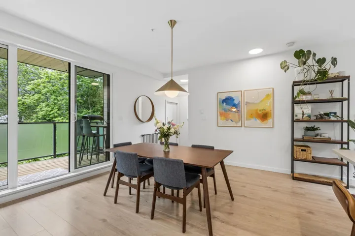 Dining area featuring light wood-finish flooring and a contemporary brass pendant light