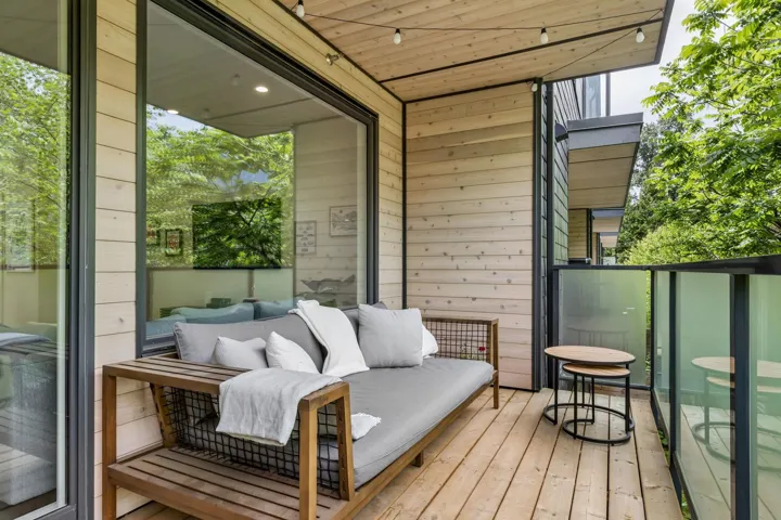 Expansive balcony featuring natural wood-finish flooring and wall paneling