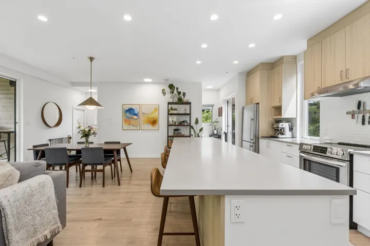 Expansive kitchen island with light wood-finish flooring throughout