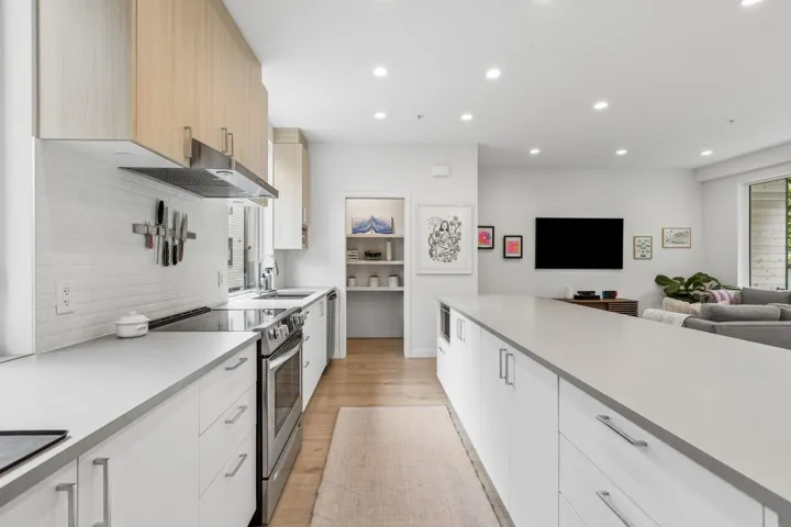 Modern kitchen featuring extensive counter space, stainless steel appliances, and wood-finish upper cabinetry