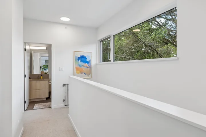 Light-filled hallway featuring a panoramic window, flush-mount lighting, and carpeted flooring
