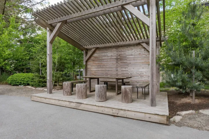 Wood pergola with slatted roof, featuring a raised deck platform