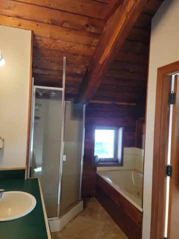 Bathroom with a stall shower, vanity, accessible from master bedroom and hallway