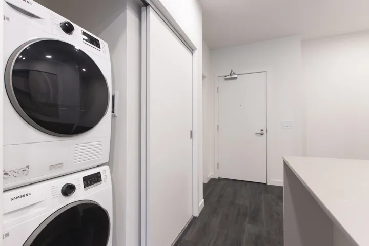 Laundry area with stacked washer / drying machine and  coat closet