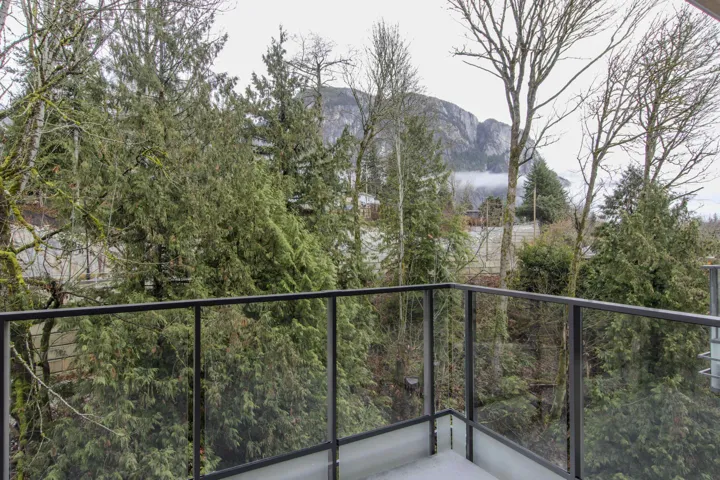 Balcony featuring a mountain view and a wooded view