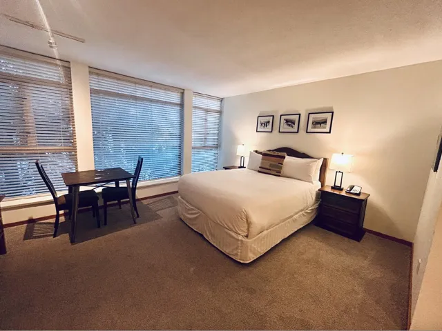 Carpeted bedroom featuring baseboards and a textured ceiling