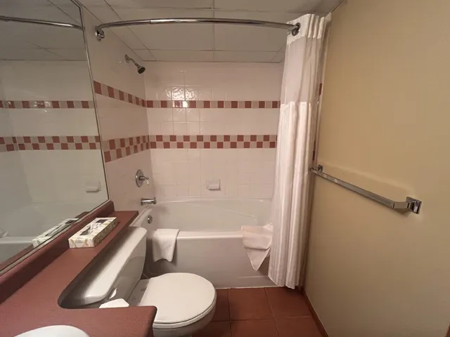 Bathroom with shower / bath combo and dark tile patterned floors