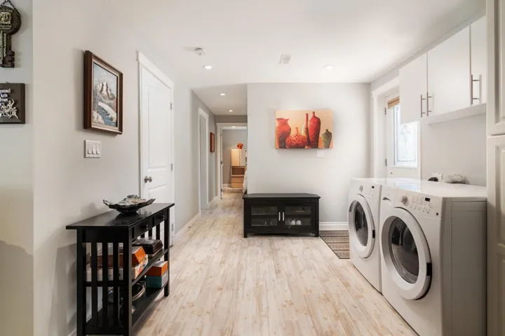 Laundry area featuring washer and dryer, light wood finished floors, baseboards, and recessed lighting