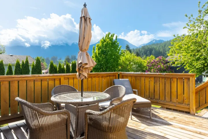 Wooden deck with outdoor dining space and a mountain view