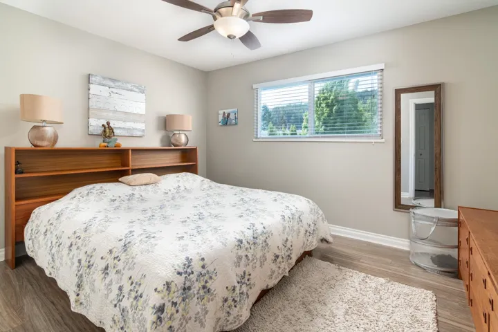 Bedroom with baseboards, wood finished floors, and ceiling fan