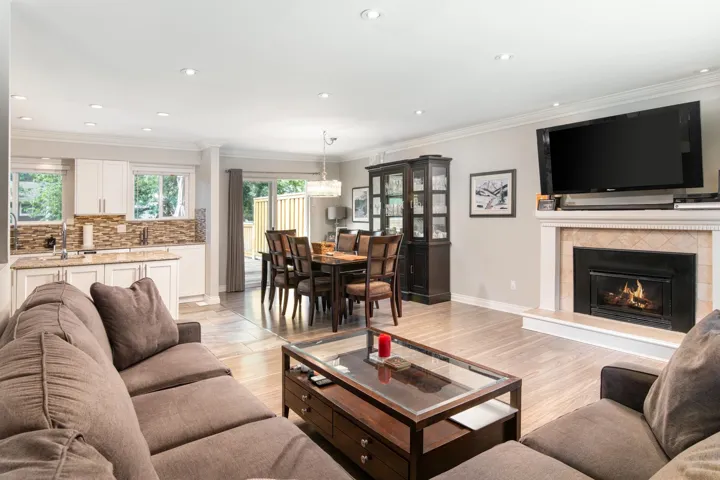 Living area featuring healthy amount of natural light, light wood-type flooring, a tiled fireplace, recessed lighting, and ornamental molding