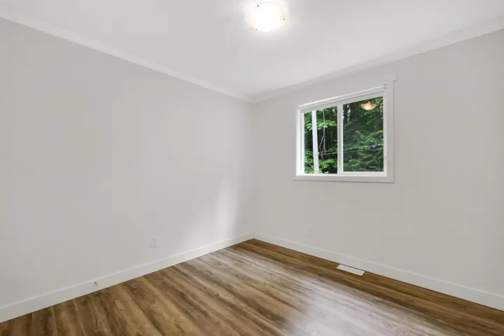 Unfurnished room with crown molding, baseboards, and wood finished floors