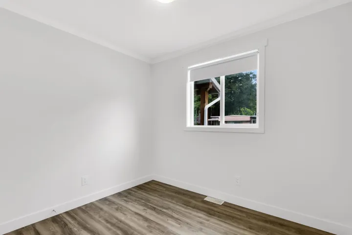 Empty room with ornamental molding, baseboards, and dark wood-style floors