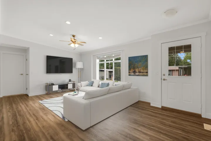 Living area featuring ornamental molding, wood finished floors, ceiling fan, baseboards, and recessed lighting