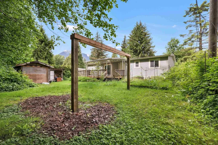 View of green lawn featuring a wooden deck