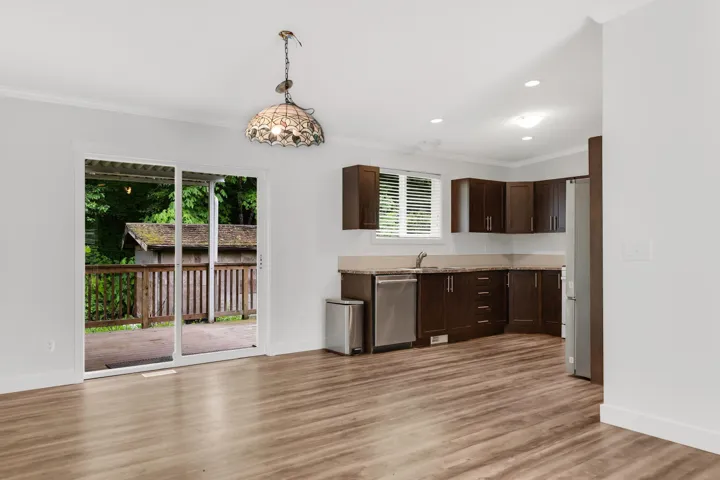 Kitchen featuring dark brown cabinetry, stainless steel dishwasher, plenty of natural light, a sink, and crown molding