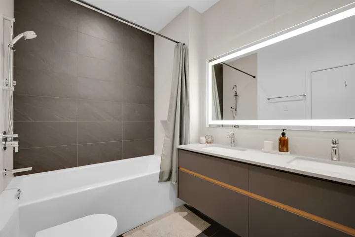 Full bath featuring shower / tub combo and double vanity